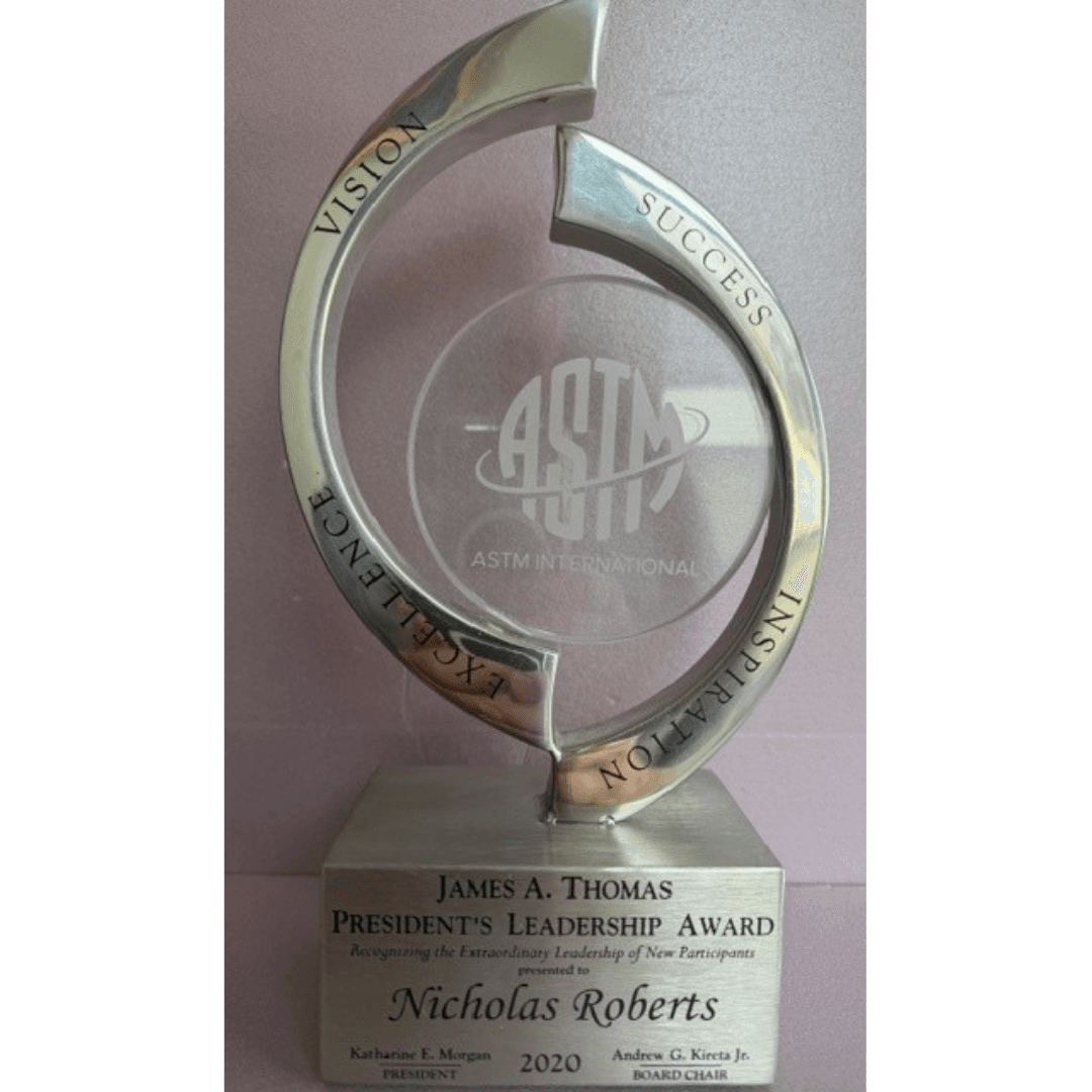 Silver ASTM International President's Leadership Award trophy with circular frame, presented to Nicholas Roberts.